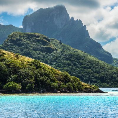 a large body of water with a mountain in the background