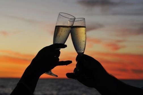 a close up of a hand with a sunset in the background